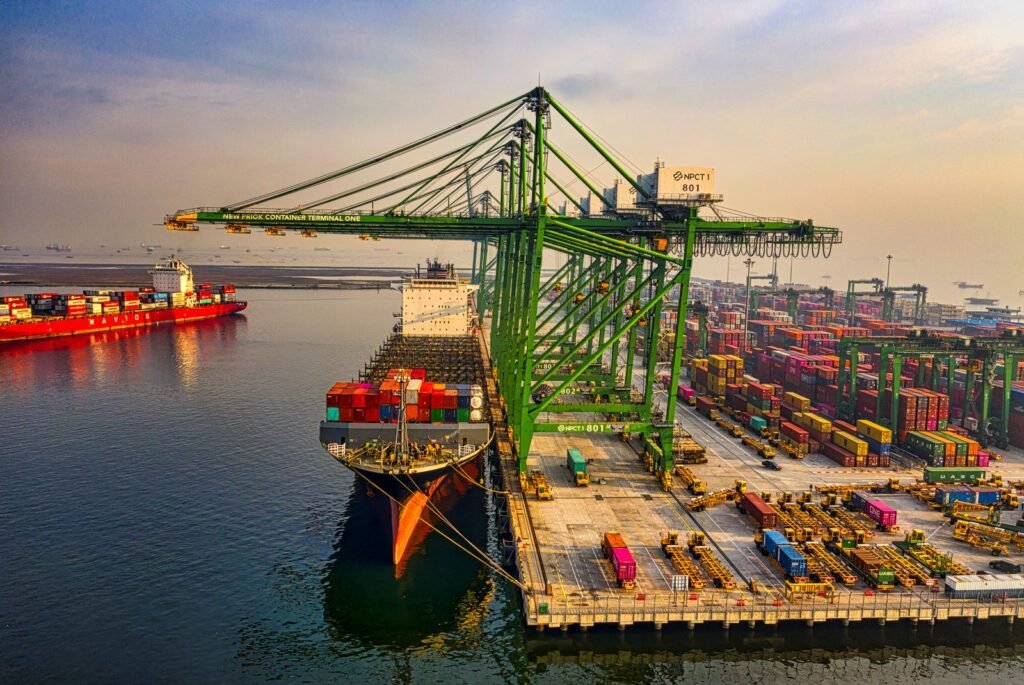 Aerial view of a container ship at berth with cranes and container yard